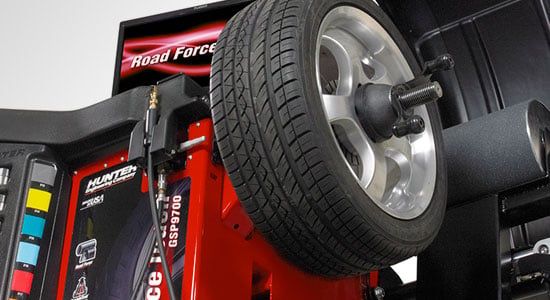 Road Force balancing machine testing a wheel and tire assembly under load